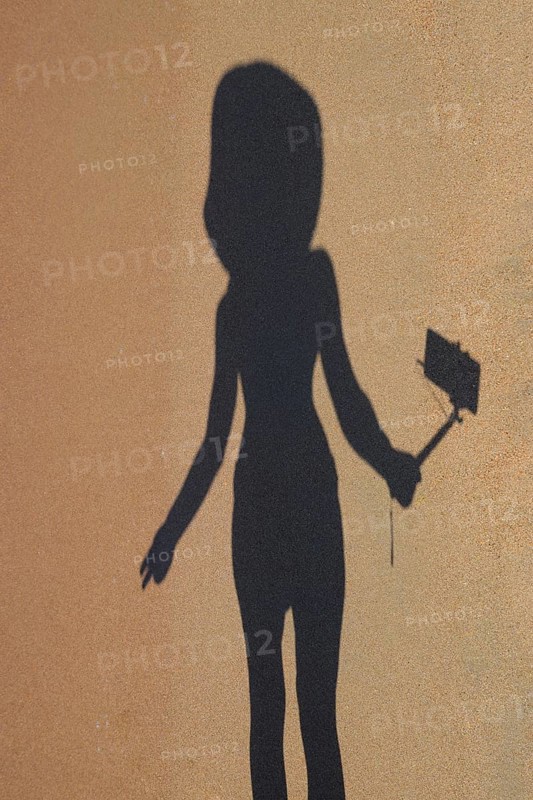 Shadow of a girl with a selfie stick on the beach. Golubitskaya, Russia