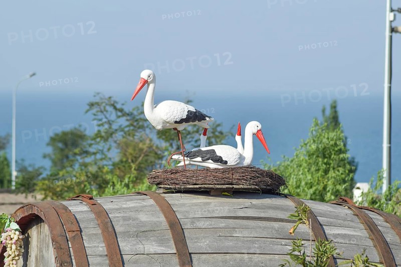 Toy nest of a stork with birds on it. Taman, Krasnodar Krai, Russia
