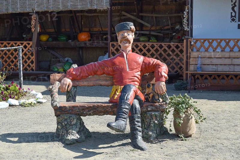 Statue in Cossack fur hat sitting on a bench with a cat. Taman, Krasnodar Krai, Russia