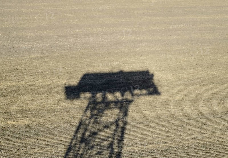 The shadow of a water tower on a plowed field. Atyrau, Kazakhstan
