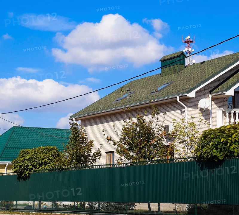 Asphalt shingle. Decorative bitumen shingles on the roof of a brick house. Atyrau, Kazakhstan