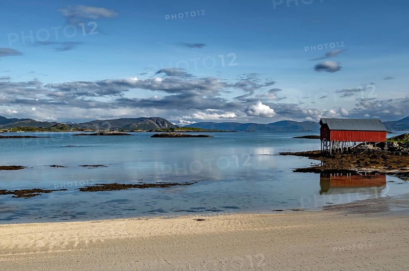 Red Hut Cottage And White Sand Beach On Sommaroy Island At Calm Fjord In Norway