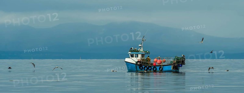 Small Fishing Boat With Lobster Pods And Seagulls On Calm Atlantic In Front Of The Hebride Islands In Scotland, United Kingdom