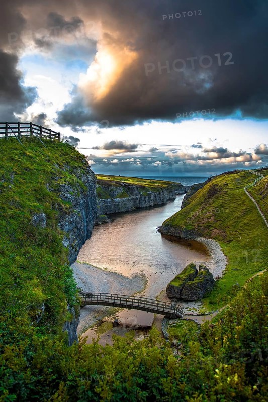Canyon And Entrance With Bridge To Smoo Cave And Atlantic Coast At Sunset Near Durness In Scotland, United Kingdom
