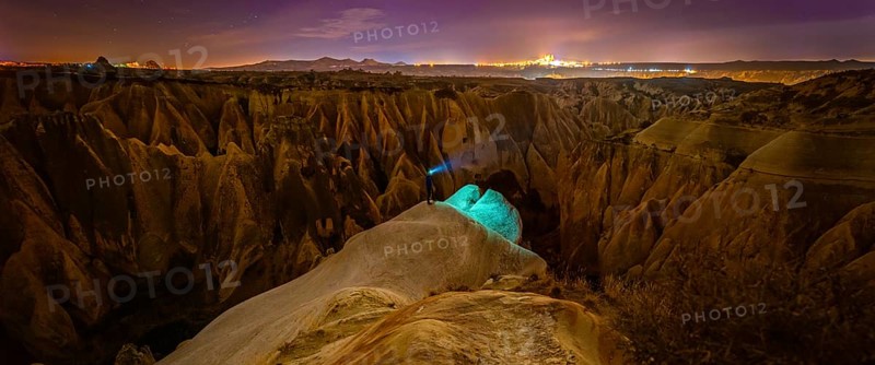 Cappadocia rose valley with male person at night posing. Turkey