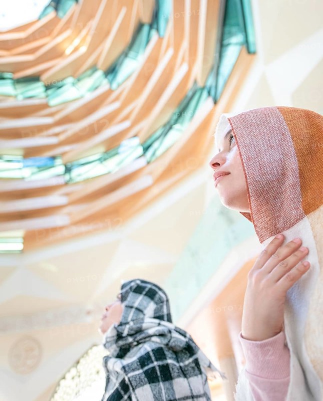 Muslim young millenial girls with scarfs during the pray in modern Marmara mosque in Istanbul. Turkey