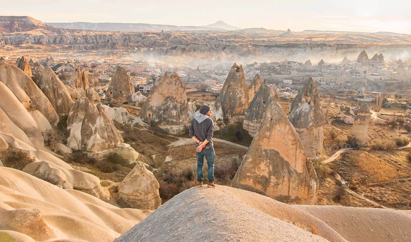 Male person with morning view of Goreme town in Cappadocia. Turkey travel