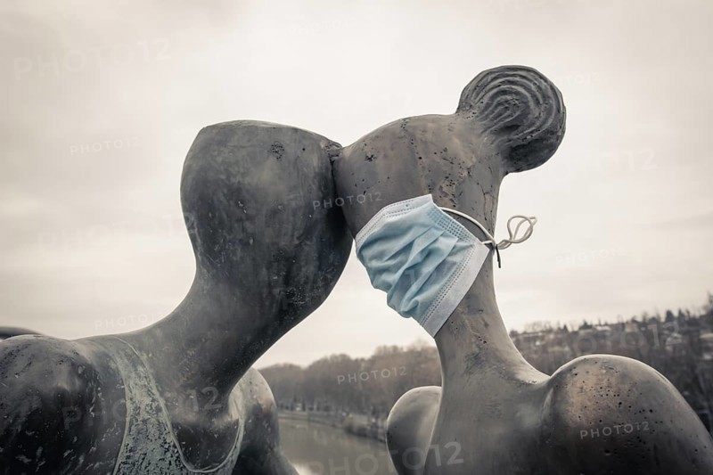 Statue of a couple with medical mask on. Concept of relationship and social distance during quarantine and pandemic of corona virus. Tbilisi.Georgia