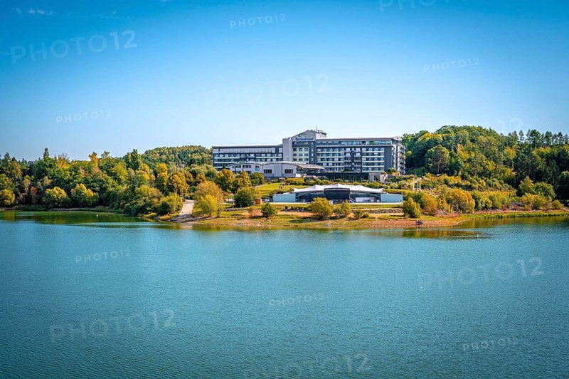 Organic lakeside hotel surrounded by trees under a clear blue sky, Zeulenrodaer Meer reservoir, Zeulenroda-Triebes, Thuringia, Germany