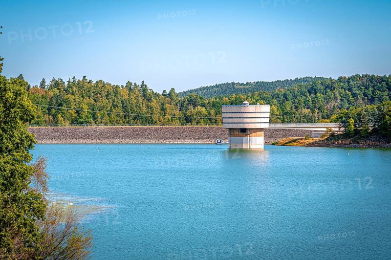 Round tower at the dam wall in the reservoir with surrounding forest and blue sky, Zeulenrodaer Meer reservoir, Zeulenroda-Triebes, Thuringia, Germany