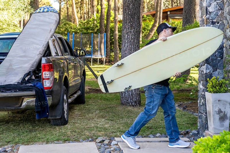 Man carrying a surfboard ready for a surfing adventure