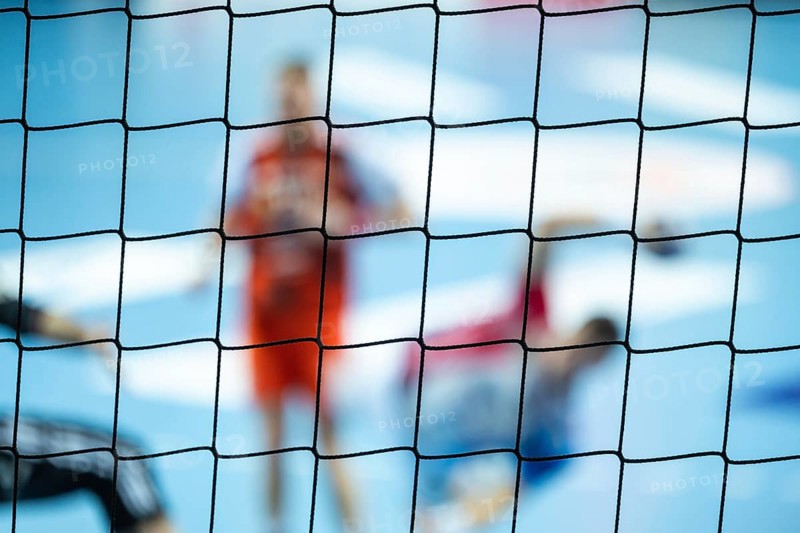 The net behind the goal and silhouette of handball players in the background. Lubin, Poland