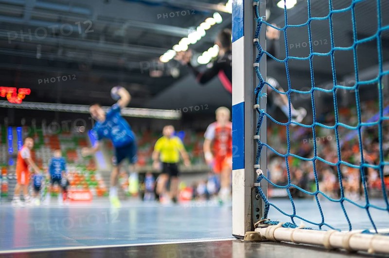 Detail of handball goal post with net and handball match in the background. handball match. Lubin, Poland