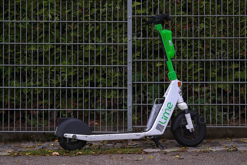 On the side of the road, fence, parked e-scooter, electric scooter, scooter, in the bike rental of the company Lime, OnLime and Uber, Stuttgart, Baden-Württemberg, Germany