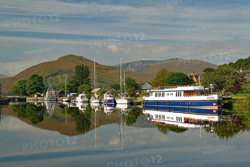 Harbour with boats and reflections under the surrounding green mountains, Caledonian Canal, Banavie, Fort William, Scotland, Great Britain