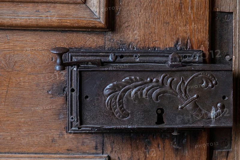 Detail of an old metal lock on a carved wooden door frame, Hesse, Germany