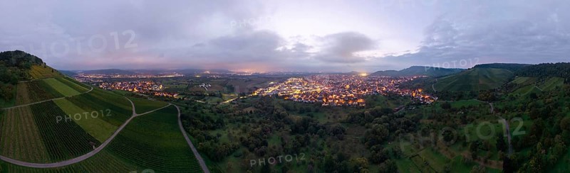 Dusk over an illuminated town, surrounded by vineyards and orchards, Korb and Kleinheppach in the Rems Valley, Baden-Württemberg, Germany
