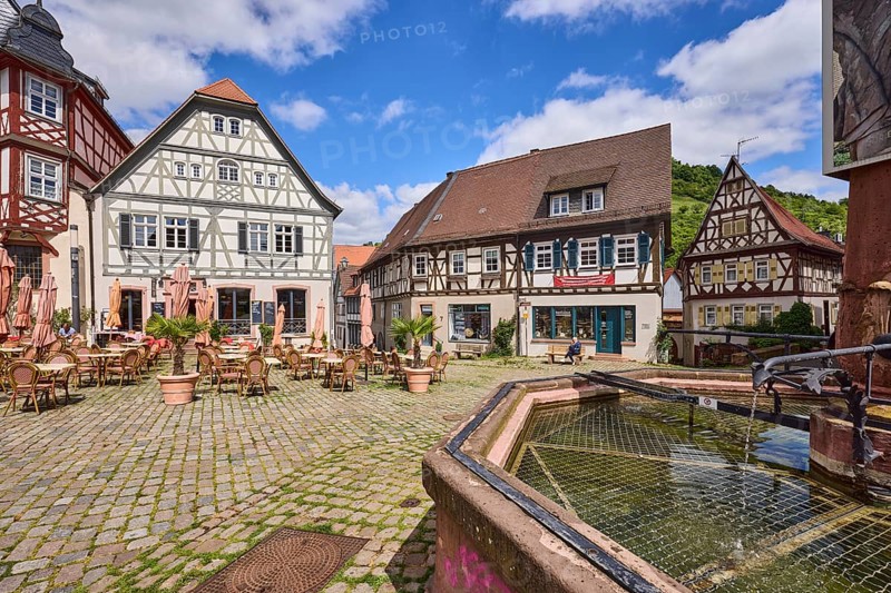 Old town, stone fountain, water, historic half-timbered houses, cobblestone square, outdoor area of a restaurant, visitors as secondary motif, blue sky, cumulus clouds, market square, intersection between Großer Markt, Marktstraße, Amtsgasse, Mühlgasse and Schunkengasse, Heppenheim, Odenwald, Bergstraße district, Hesse, Germany