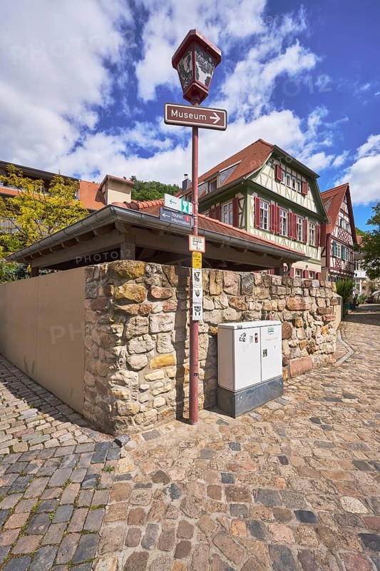 Old town, lantern, signpost to the museum, quarry stone wall, historic half-timbered houses, buildings, trees, blue sky, cumulus clouds, intersection Kleine Bach with Amtsgasse, Heppenheim, Odenwald, Bergstrasse district, Hesse, Germany