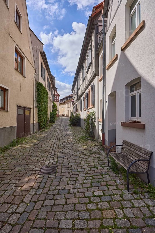 Old town, alley, cobblestone pavement, historic half-timbered houses, historic buildings, facades with windows, bench, shady, blue sky, cumulus clouds, Kleine Bach, Heppenheim, Odenwald, Bergstrasse district, Hesse, Germany