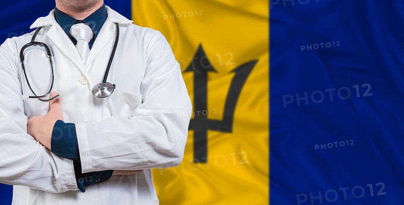 Male doctor with stethoscope on Barbados flag. Doctor holding stethoscope on Barbados flag