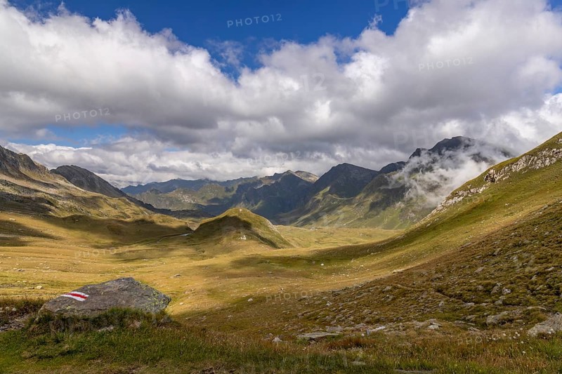 View from Passo del Sole in Alpe Carorescio with Piano Grande plateau and hiking trail marker, Quinto, Ticino, Switzerland