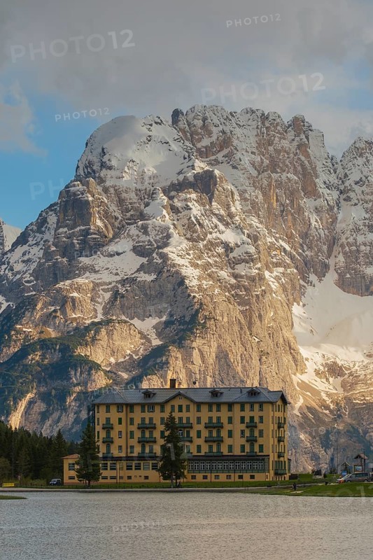 View over Lake Misurina to a building on the shore of the lake with a view towards the Sorapis mountain group, Misurina, Dolomites, Province of Belluno, Veneto, Italy