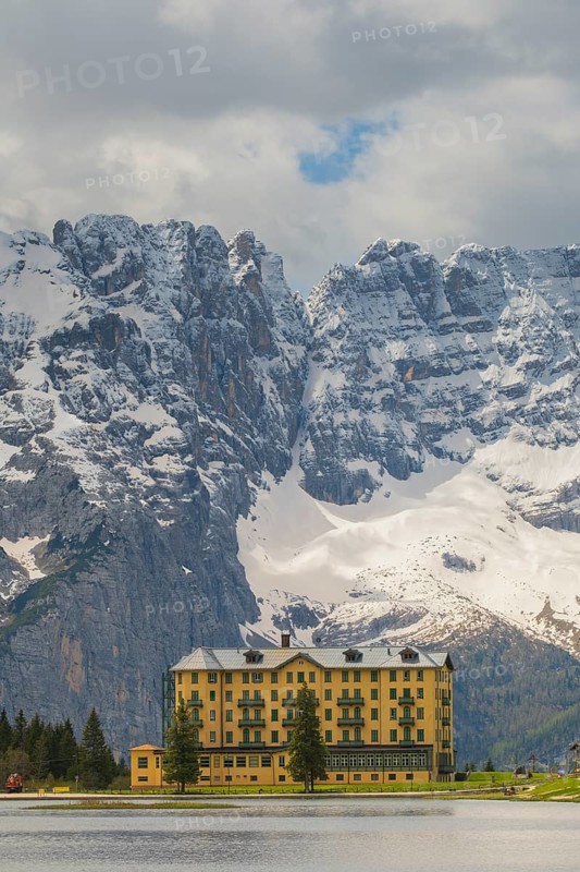 View over Lake Misurina to a building on the shore of the lake with a view towards the mountain Punta Sorapis, Misurina, Dolomites, Province of Belluno, Veneto, Italy