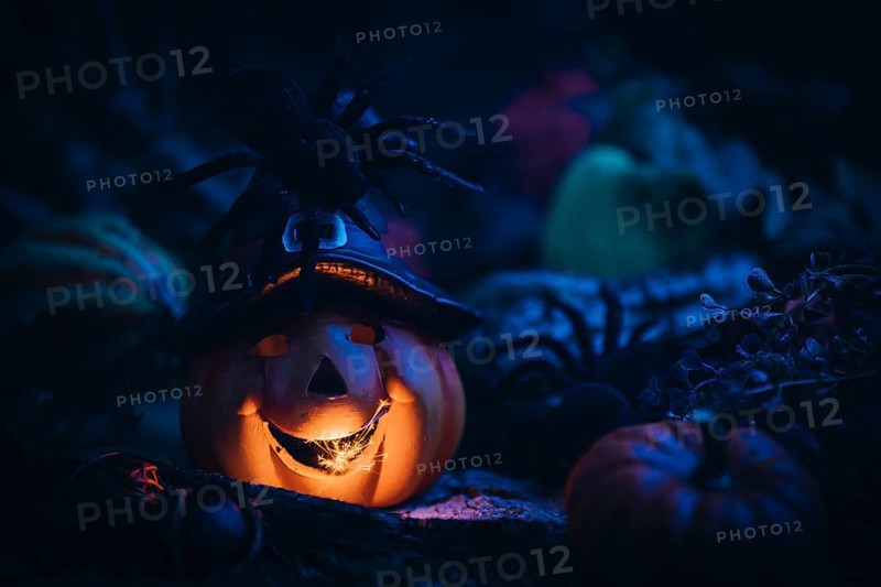 Glowing pumpkin with witch's hat, surrounded by spiders and other pumpkins, Halloween atmosphere