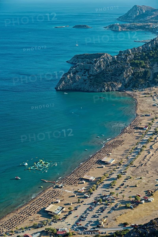 View of the sunny coastal landscape of Tsambika with sandy beach, blue sea and cliffs, Church of the Virgin Mary Tsambika (Kyra Psili), Archangelos, Rhodes Island, Greece