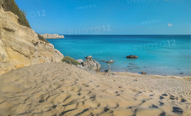 Tsambika beach with fine sand and large rocks on a sunny day, azure blue water and clear sky, Tsambika beach, Archaggelos, Rhodes island, Greece