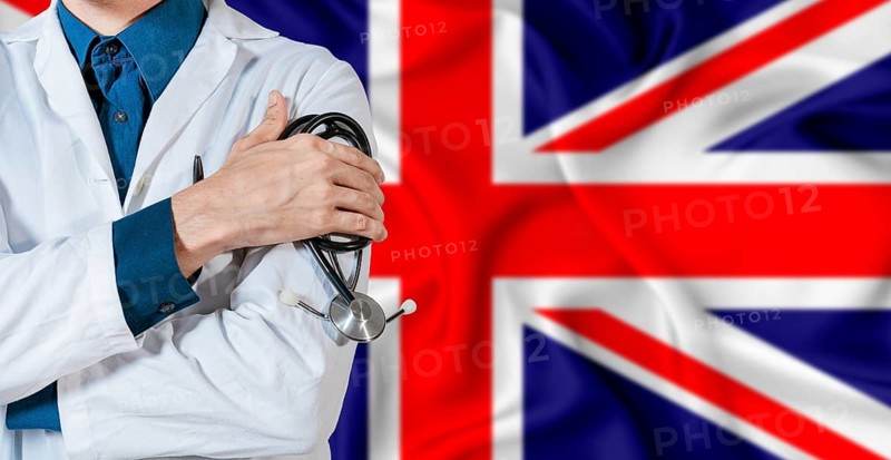 Doctor with stethoscope on United Kingdom flag. Doctor holding stethoscope on British flag
