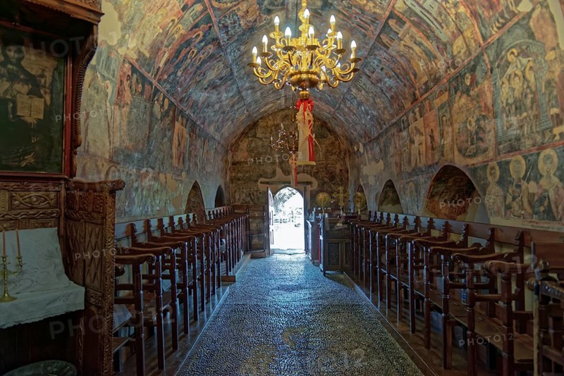 Historic church interior with paintings and a decorative chandelier, conveying a calm and venerable atmosphere, Greek Orthodox Church Kimisis tis Theotokou, Asklipiio, Rhodes Island, Greece