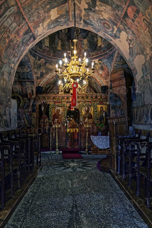 Magnificently decorated church interior with frescoes and a large candlestick that creates a spiritual atmosphere, Greek Orthodox Church Kimisis tis Theotokou, Asklipiio, Rhodes Island, Greece