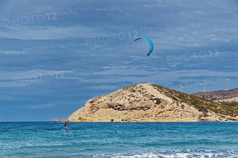 Prasonisi beach with a view of the sea and rocky island with visible kite and wind turbines. Windy coastal landscape, Prasonisi, Rhodes Island, Greece