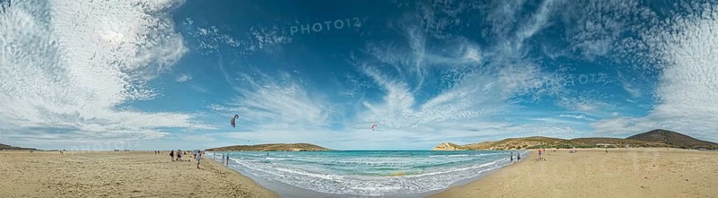 Beach panorama of Prasonisi with light sand, blue sea and two kite surfers under a cloudy sky, Prasonisi, Rhodes Island, Greece