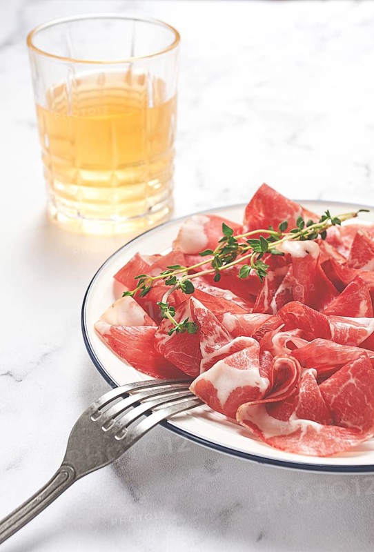 Plate with sliced cured meat, pork neck, prosciutto coppa, Italian delicacy