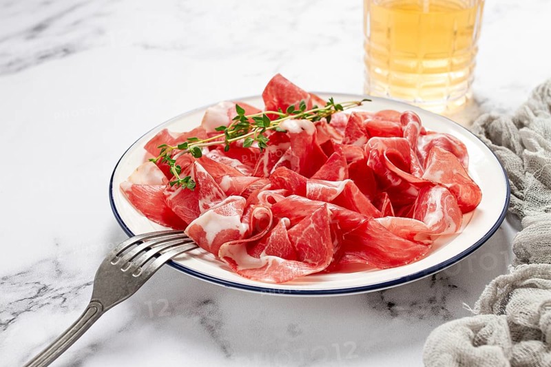 Plate with sliced cured meat, pork neck, prosciutto coppa, Italian delicacy