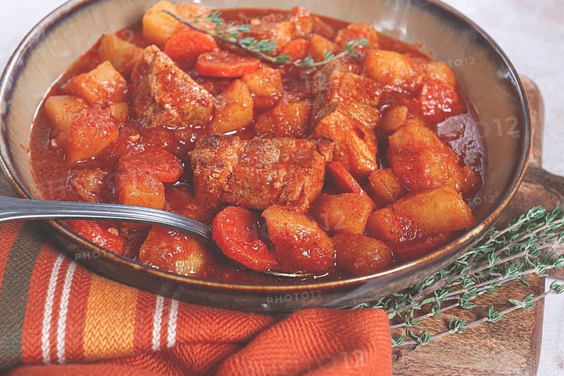 Meat goulash with potatoes and carrots, sweet peppers, in a saucepan, top view, traditional Hungarian soup, homemade, no people