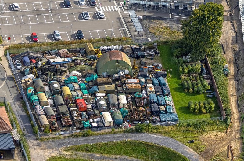 Aerial view, scrap yard with old military trucks at Friedrichsfeld (Lower Rhine) railway station, Friedrichsfeld, Voerde, Ruhr area, North Rhine-Westphalia, Germany, railway area, railway station, platform, DE, Deutsche Bahn AG, Europe, railway tracks, tracks, aerial view, aerial photography, aerial photography, Lower Rhine, scrap trade, overview, Voerde (Lower Rhine), bird's-eye view, recycling, birds-eyes view, overview