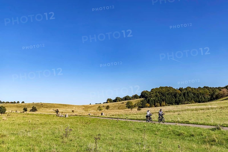 Pristine landscape in the Swabian Alb biosphere reserve with blue skies and cyclists. The former military training area in Münsingen is an important part of the 85, 270-hectare nature reserve. It was established by the state of Baden-Württemberg in 2008. It has been a UNESCO biosphere reserve since 2009. Münsingen, Baden-Württemberg, Germany