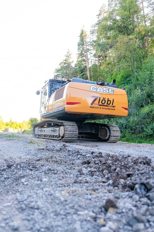 A large excavator on a construction site with trees in the background, Hermann Hessebahn construction site, Calw, Germany