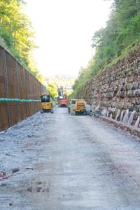 Construction site with heavy machinery on a stony road between steep embankments, Hermann Hessebahn construction site, Calw, Germany