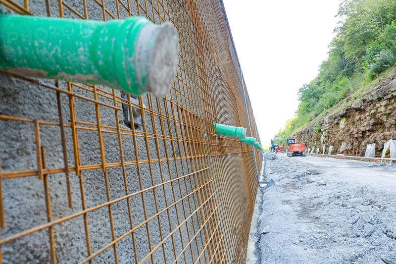 Close-up of a construction wall with metal mesh and green pipes, Hermann Hessebahn construction site, Calw, Germany