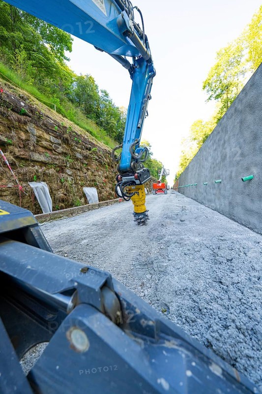 Close-up of crane arm on construction site, surrounded by concrete wall and trees, Hermann Hessebahn construction site, Calw, Germany