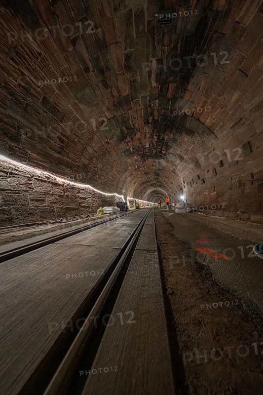 Dark tunnel with rails and lighting along the tunnel walls, construction of the Hermann Hesse railway, Calw, Black Forest, Germany