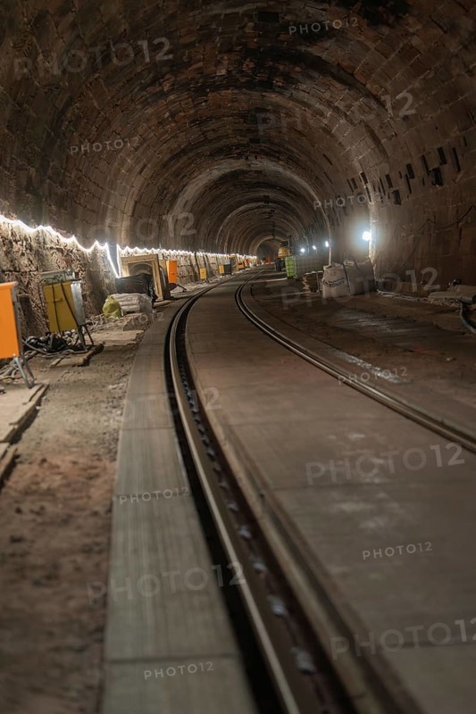 An illuminated railway tunnel, partly construction site with visible brick walls, construction of the Hermann Hesse railway, Calw, Black Forest, Germany