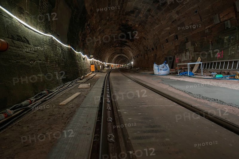 A tunnel with stone walls and railway tracks, illuminated and with building accessories, construction of the Hermann Hesse railway, Calw, Black Forest, Germany