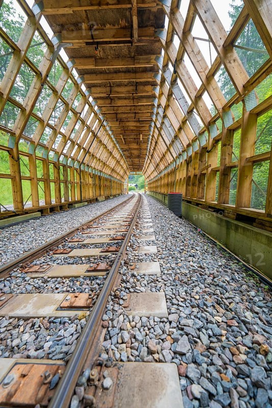 Open wooden tunnel with a view of daylight through wooden structures, construction of the Hermann Hesse railway, Calw, Black Forest, Germany