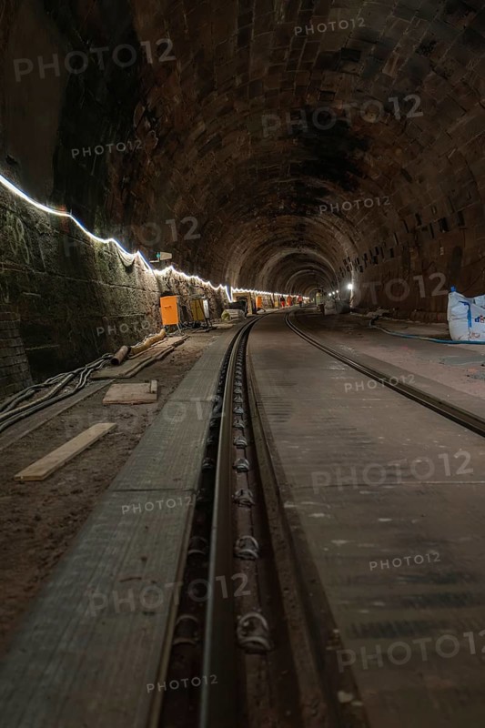 Long stone tunnel with lighting and construction equipment along the track, construction of the Hermann Hesse railway, Calw, Black Forest, Germany